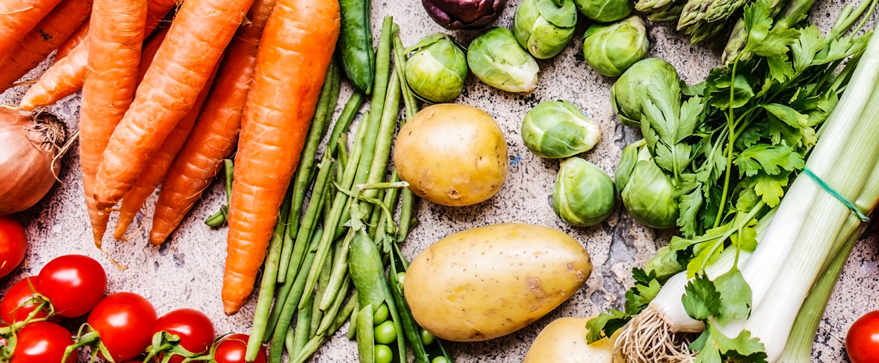 Frisches Gemüse wie Karotten, Kartoffeln und Tomaten, ideal für den Saisonkalender zur saisonalen Ernährung.