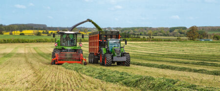 Zwei Traktoren arbeiten auf einem Feld, um Gras für die Agrartechnik zu ernten und zu transportieren.