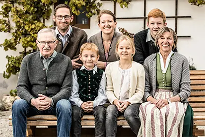 Eine multikulturelle Familie sitzt auf einer Bank und symbolisiert die Werte von Heimat der Vielfalt.