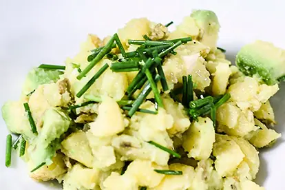 Avocado-Kartoffelsalat mit frischen Kräutern und cremiger Textur auf einem weißen Teller.