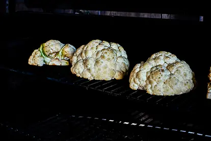 Geräucherter Blumenkohl auf dem Grill, perfekt zubereitet für ein aromatisches Geschmackserlebnis.