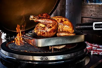 Saftiges Hähnchen und Würstchen auf einem Grill, ideal für Wintergrillen und geselliges Beisammensein im Freien.