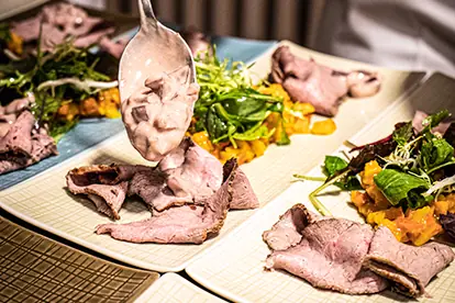 Rosa Tafelspitz vom Kalb wird auf Kürbis-Apfelragout und Joghurt-Zwetschgensugo angerichtet.