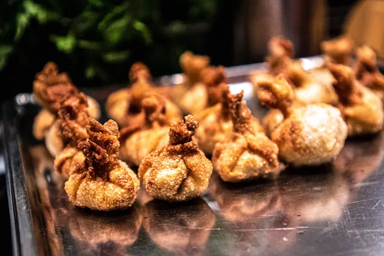 Frittierte Teigtaschen, die im Milchworkshop zubereitet wurden, auf einem Blech angerichtet.