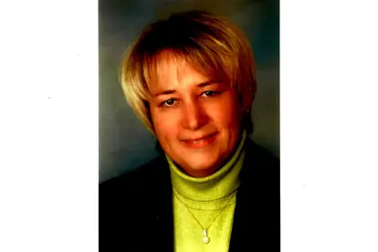 Porträt einer Frau mit blonden Haaren und grünem Pullover, die auf der Seite über Quarknudeln präsentiert wird.
