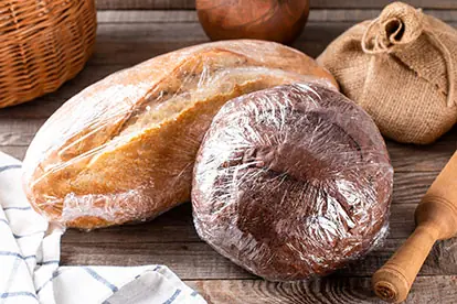 Verpacktes altes Brot auf einem Holztisch, ideal zum Verwerten und Verarbeiten in verschiedenen Rezepten.