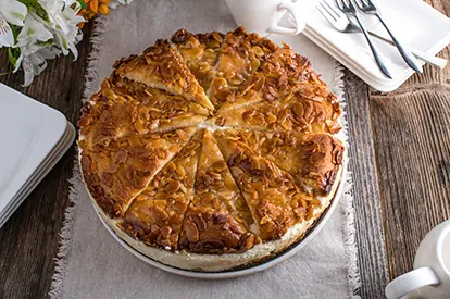 Bienenstichkuchen mit goldbrauner Mandelschicht, auf einem rustikalen Tisch serviert, ideal für Kaffeepausen.