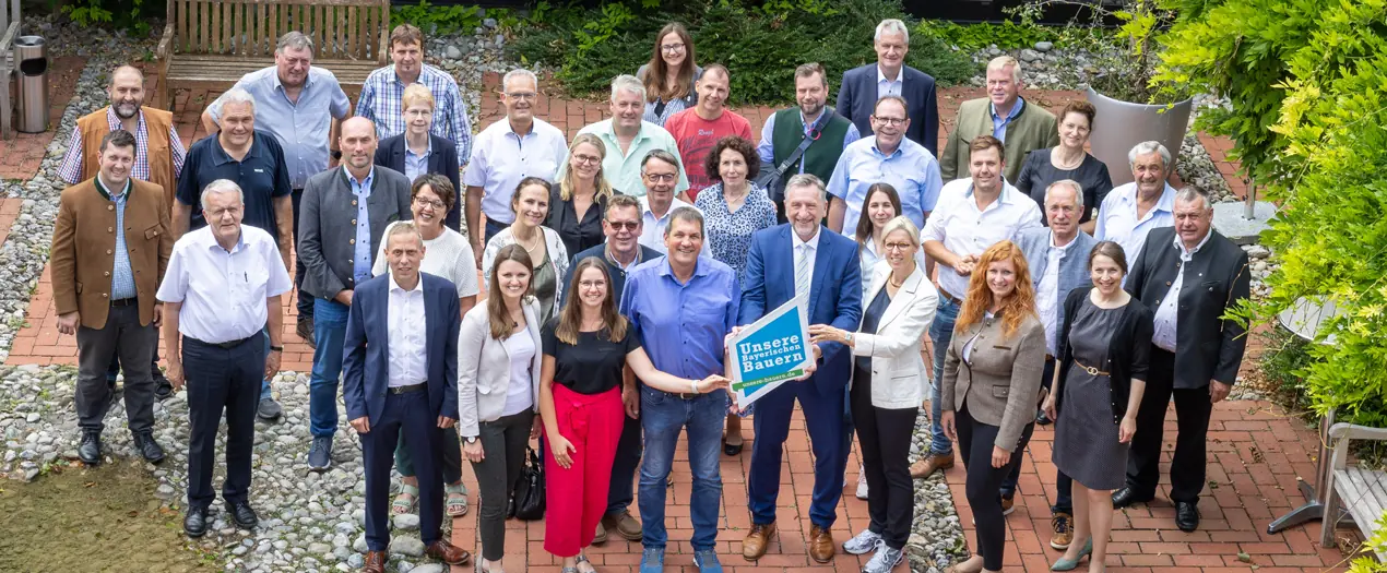 Gruppenfoto von Teilnehmern einer Veranstaltung, die Dankbarkeit und Zusammenarbeit in einer Gartenumgebung ausdrücken.