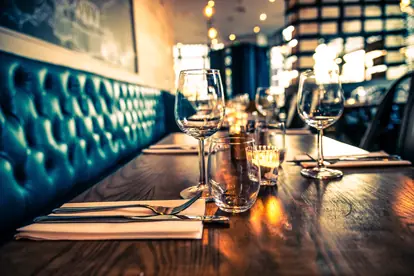 Elegant gedeckter Tisch mit Gläsern und Kerzen in modernem Restaurantambiente.