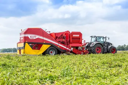 Moderne Agrartechnik zeigt einen Traktor mit einer Erntemaschine auf einem Feld.