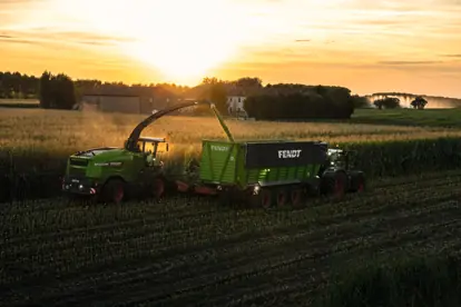 Fendt Traktoren ernten bei Sonnenuntergang Mais, ein Beispiel für moderne Agrartechnik in der Landwirtschaft.