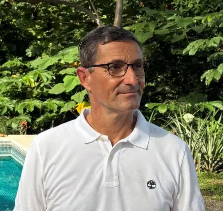 Dr. Martin Kussmann, Leiter Ernährungswissen und Innovation am Kompetenzzentrum für Ernährung (KErn), im weißen Poloshirt mit Brille vor grünen Pflanzen im Freien.